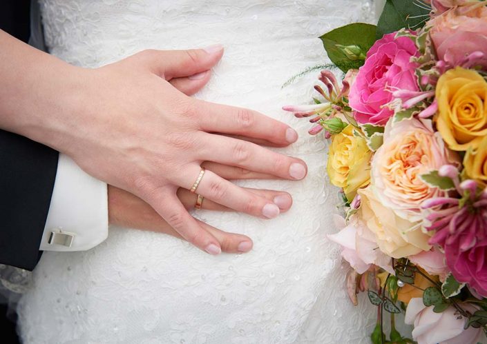 Nærbillede af hænder og brudebuket